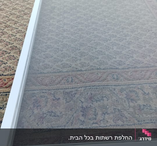 רשת אלומיניום לבנה לחלון מונחת לפני התקנה